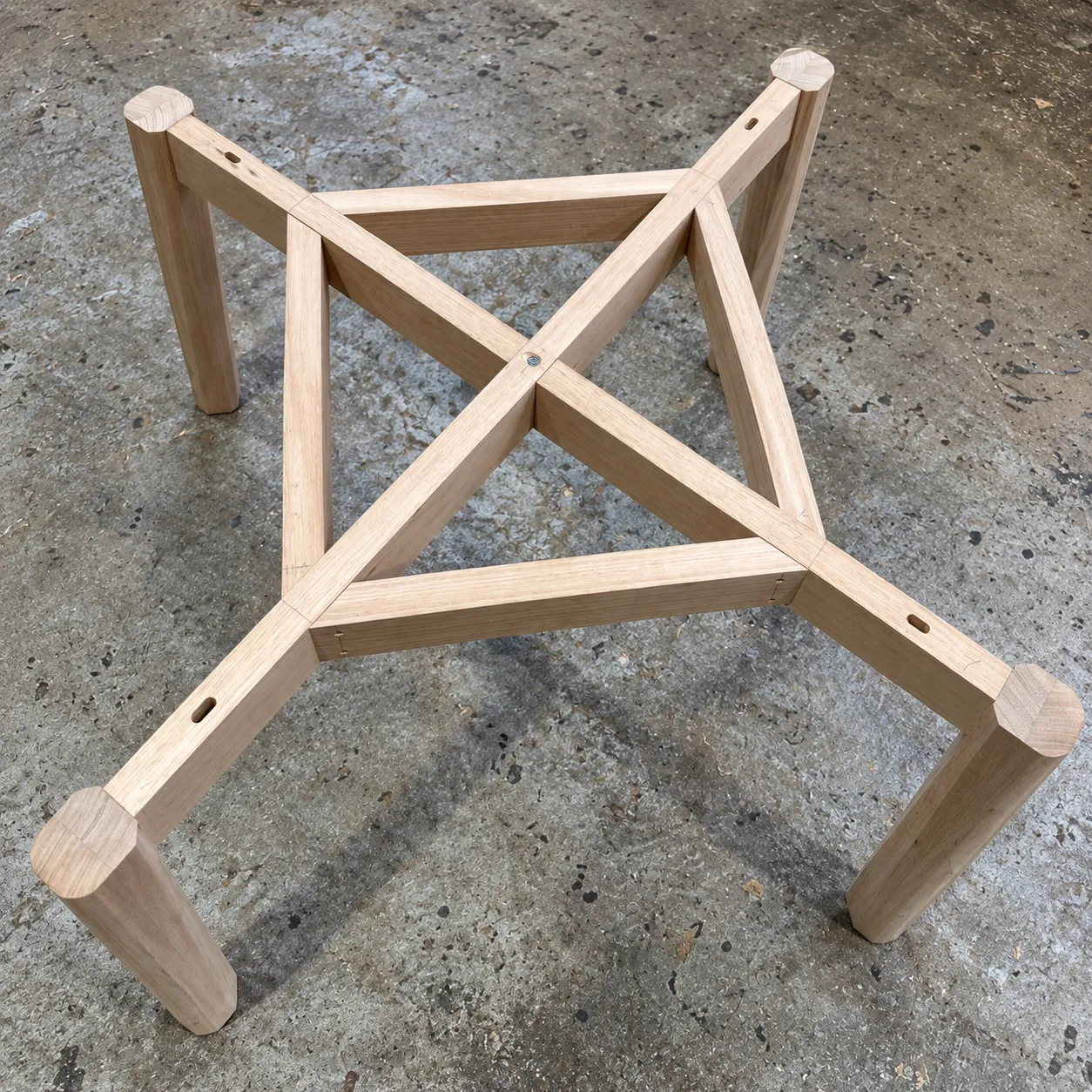 The Kolo Table underframe in the workshop — four legs and crossing rails